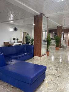 a blue couch in a living room with a man in the background at Hotel Costa Linda Beach Boca Chica in Boca Chica