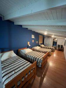 three beds in a room with blue walls at Casa Monte in Monte Hermoso