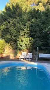 - deux bancs blancs installés à côté d'une piscine dans l'établissement Casa Monte, à Monte Hermoso