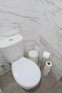 La salle de bains est pourvue de toilettes blanches et d'un mur en marbre. dans l'établissement Lisbon Key Hub - Rooms 1-5, à Lisbonne