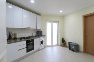 cocina con armarios blancos, lavadora y secadora en Lisbon Key Hub - Rooms 1-5 en Lisboa