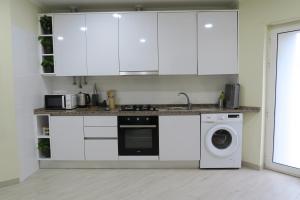 a kitchen with white cabinets and a washing machine at Lisbon Key Hub - Rooms 1-5 in Lisbon