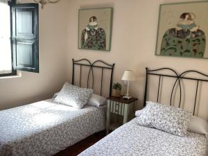 2 Betten in einem Zimmer mit 2 Bildern an der Wand in der Unterkunft EL HOGAR DE LA CASTAÑERA in Colombres