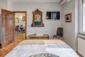 a bedroom with a bed and a table and a mirror at Grand Square Suite - Tale Of The City in Zagreb