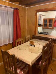 a dining room with a table with chairs and a kitchen at Arriendo casa en NELTUME a minutos de huilo-huilo in Neltume