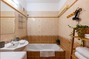 Un baño con bañera blanca y lavabo. en Duna Retreat: City Serenity, en Bratislava 39 fotos más