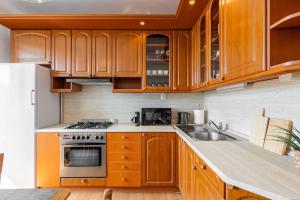 Una cocina con gabinetes de madera y un horno de estufa. en Duna Retreat: City Serenity, en Bratislava