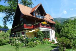 a house with a balcony and flowers in the yard at Appartement Intermezzo in Ried