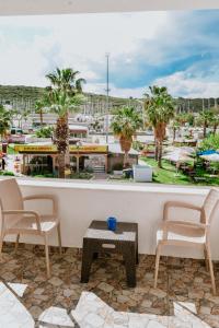 e balcone con vista su un resort, sedie e tavolo. di Pia Butik Otel Sığacık a Smirne