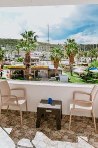 - un balcon avec une table et des chaises offrant une vue sur un complexe dans l'établissement Pia Butik Otel Sığacık, à Izmir