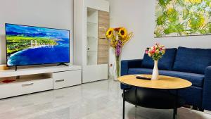 sala de estar con sofá azul y TV en Emily’s Apartment en Blaustein