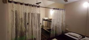 baño con ducha con cortina blanca en Tribal Woods Resorts, en Dhanwār