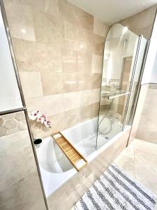 a bathroom with a shower and a white tub at 22nd Floor Luxury City Centre Apartment in Belfast