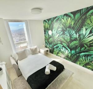 une chambre avec un lit avec un papier peint tropical dans l'établissement 22nd Floor Luxury City Centre Apartment, à Belfast