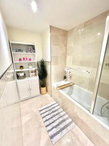 a bathroom with a shower and a bath tub at 22nd Floor Luxury City Centre Apartment in Belfast