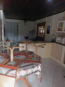 a group of four chairs sitting in a kitchen at Casa com Piscina na Morada da Praia in Bertioga