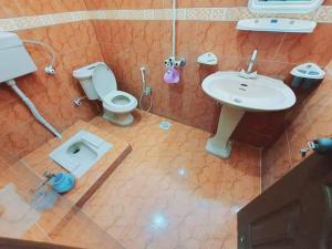 La salle de bains est pourvue de toilettes et d'un lavabo. dans l'établissement FAMIlYGUESTHOUSE KARACHIAIRPORT, à Karachi