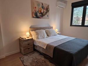 a bedroom with a bed and two lamps on a night stand at Holiday in Trebinje Apartment in Trebinje