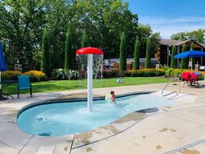 una persona en una piscina con una sombrilla roja en The Lake Fish-Amazing Views-Sleeps 24-indoor-outdoor pools, en Branson