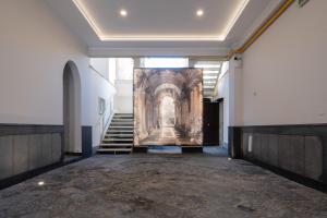 een lege hal met trappen en een schilderij aan de muur bij Palazzo Adele in Ercolano