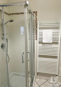 y baño con ducha y puerta de cristal. en Made in Langhe Apartment, en La Morra