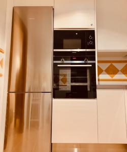 a stainless steel refrigerator and microwave in a kitchen at Hestía Vera Thalassa SPA Tu hogar lejos de casa in Vera