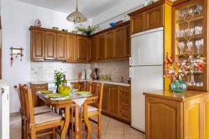 a kitchen with wooden cabinets and a white refrigerator at Sofia's House - Skopelos Town in Skopelos Town