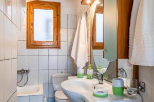 a bathroom with a sink and a toilet and a mirror at Sofia's House - Skopelos Town in Skopelos Town +25 photos