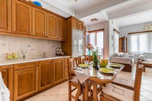 a kitchen with wooden cabinets and a table and chairs at Sofia's House - Skopelos Town in Skopelos Town