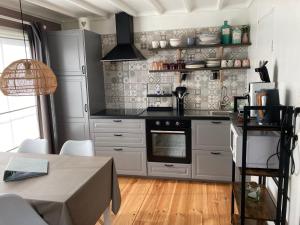 a kitchen with white cabinets and a black counter top at Chalet Happiness in Zutendaal