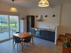 a kitchen with a wooden table and a table and chairs at Superbe logement "Loulaloue" ! in Ornans