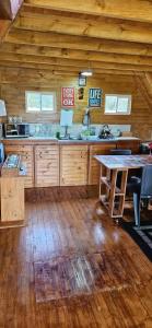 una cocina con armarios de madera y una mesa en una cabaña en Cabaña el rincon de la abuela en Guasca