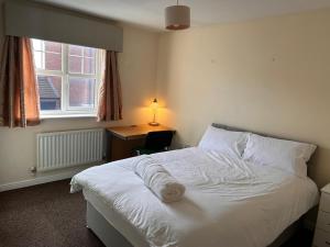 a bedroom with a bed and a desk and a window at Vyna Place-Close to City Hospital in Nottingham