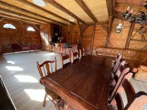 a dining room with a wooden table and chairs at Łęgowska Dolina in Olecko