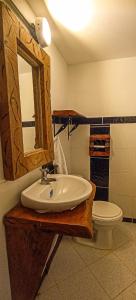 a bathroom with a sink and a toilet at Curigua Ecolodge-Sendero Cascada la milagrosa Buga in La Primavera
