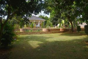 una casa con porche y un patio con árboles en Isabirye residence, en Kampala