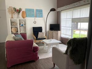 una sala de estar con un perro en una silla en Chalet Happiness en Zutendaal
