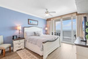 a bedroom with a white bed and a balcony at San Carlos 1503 in Gulf Shores