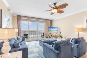 a living room with two blue couches and a flat screen tv at San Carlos 1503 in Gulf Shores +42 photos