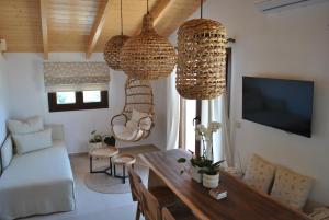 a living room with a table and some chandeliers at Amaryllis Luxury Suite in Parga