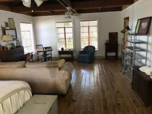 a living room with a couch and a table at Acadiana Hideaway Tiny House in Lafayette
