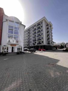 een groot appartementencomplex naast een parkeerplaats bij Апартаменти в центрі Трускавця in Truskavets