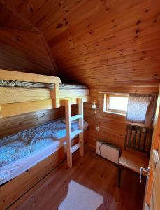 a bedroom with two bunk beds in a log cabin at Nordsjøvegen in Klepp