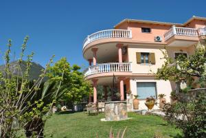 a large house with a balcony on a yard at Amaryllis Luxury Suite in Parga