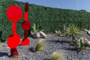a garden with red spoons in front of a hedge at My pod Capsule Boutique Airport in Ezeiza