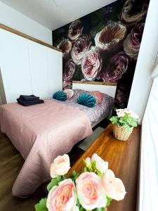 two beds in a room with a mural of roses at Apartament Chełm in Chełm