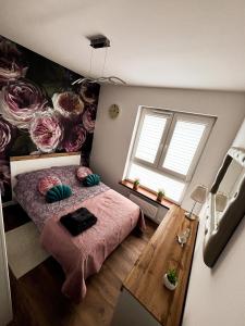 - une petite chambre avec un lit et une fresque florale dans l'établissement Apartament Chełm, à Chełm