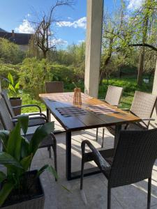een houten tafel en stoelen op een patio bij Konjic Lakeside Resort in Konjic