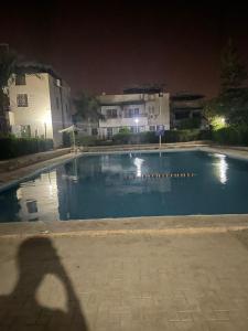 an empty swimming pool at night with buildings at villa tulipe in Ain Sokhna