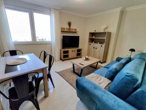 a living room with a blue couch and a table at Apartamento en Fisterra con vistas al mar, 3º sin ascensor in Fisterra